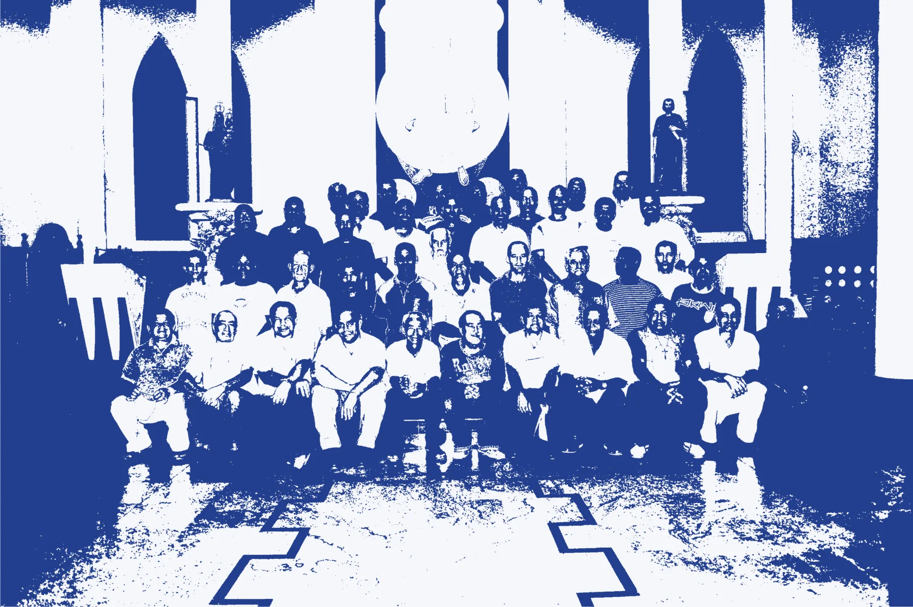 Foto antiga, em preto e branco, de um grande grupo de homens sentados diante do altar da Catedral