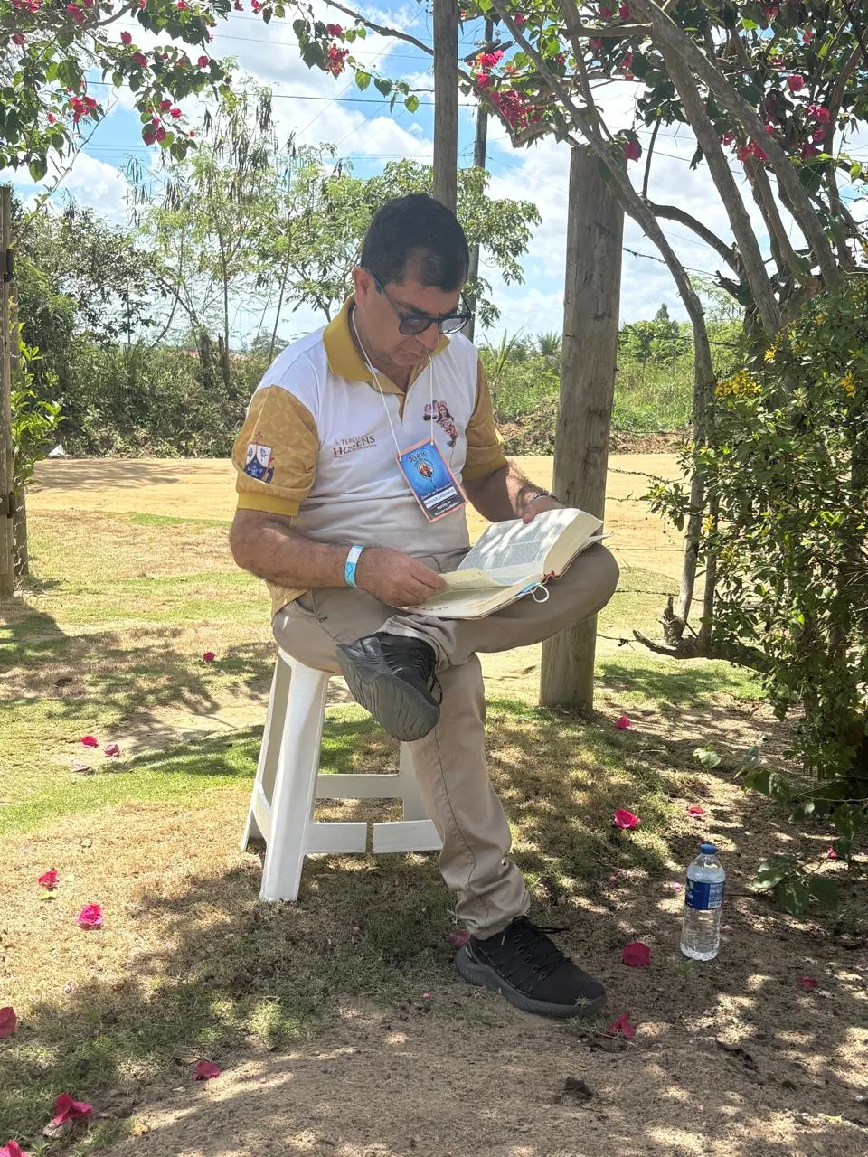 Homem do Terço dos Homens lendo a Bíblia, sentado ao ar livre durante o retiro